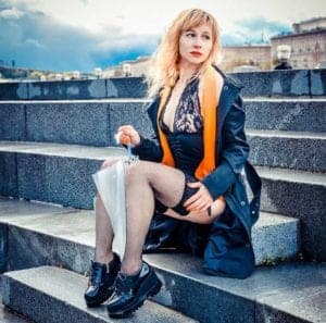 Frau mit Regenjacke und Schirm